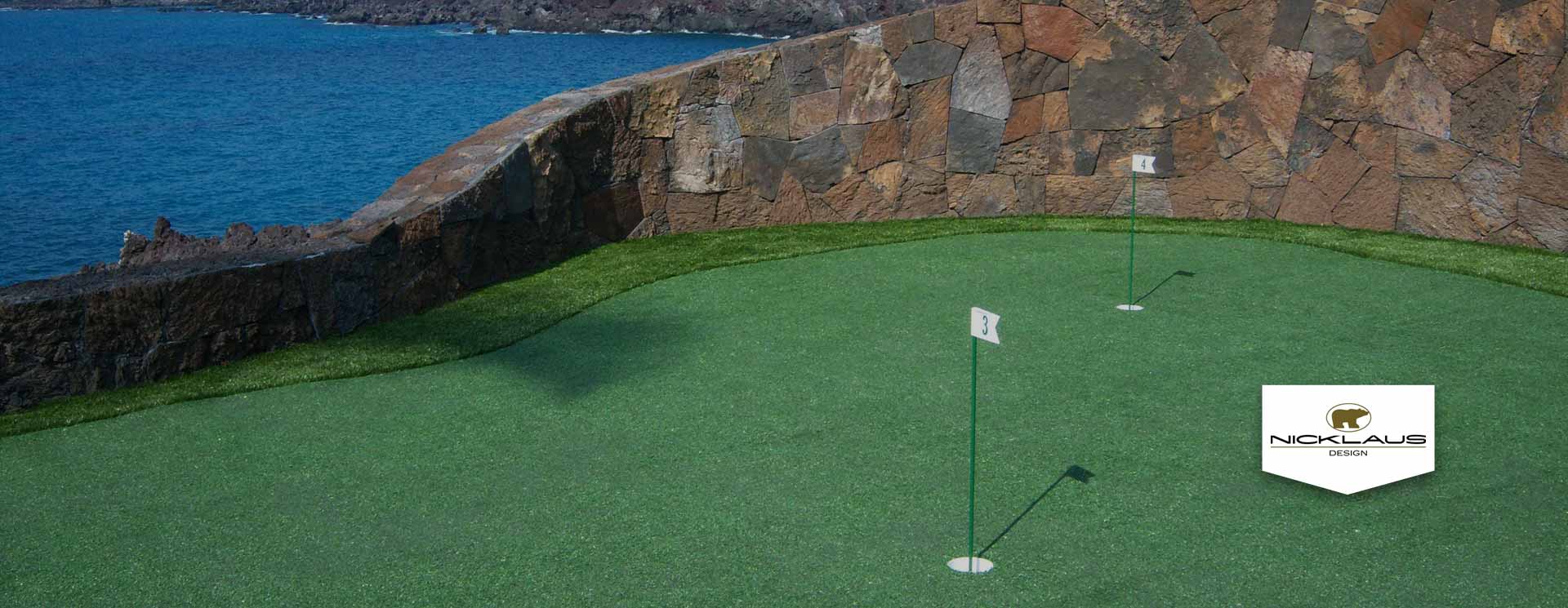 Putting green cut into lava rock with ocean horizon behind